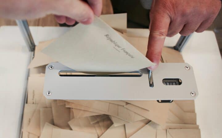 person holding white machine on top of white table
